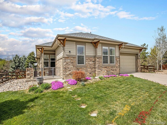 19379 W 57th Pl, Golden, CO 80403 - prairie-style house featuring fence, stone siding, a front yard, and concrete driveway