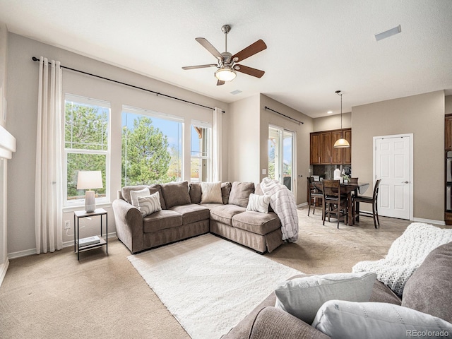 19379 W 57th Pl, Golden, CO 80403 - living area with baseboards, ceiling fan, light carpet, and a wealth of natural light