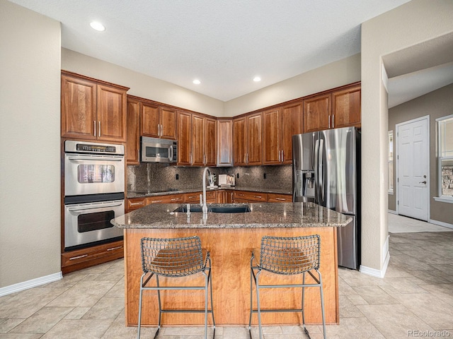 19379 W 57th Pl, Golden, CO 80403 - kitchen with a sink, appliances with stainless steel finishes, baseboards, and dark stone counters
