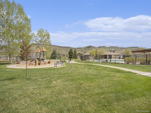 19379 W 57th Pl, Golden, CO 80403 - surrounding community with fence, playground community, a pool, a mountain view, and a yard