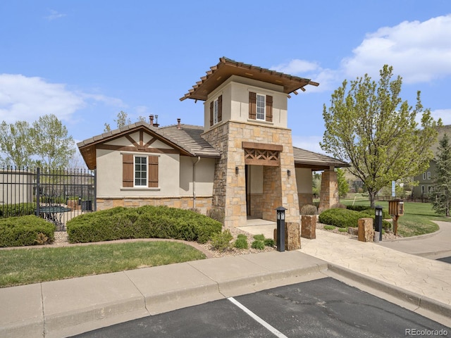 19379 W 57th Pl, Golden, CO 80403 - view of front of property with fence, stucco siding, a tile roof, and stone siding