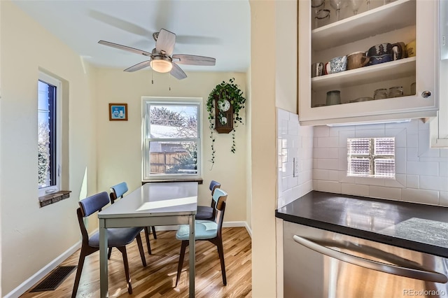 dining area featuring light wood-type flooring, visible vents, and baseboards