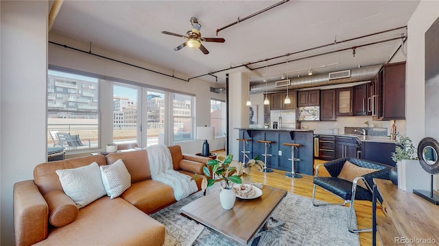 living room featuring ceiling fan and light hardwood / wood-style floors