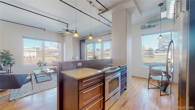 kitchen with ceiling fan, light hardwood / wood-style flooring, stainless steel appliances, and decorative light fixtures