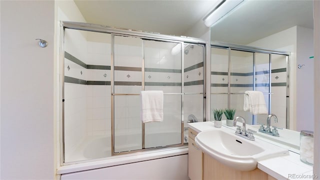 bathroom with vanity and shower / bath combination with glass door