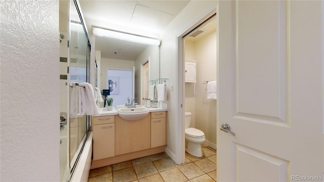 full bathroom featuring shower / bath combination with glass door, vanity, and toilet