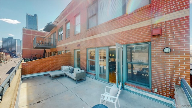 view of patio with an outdoor living space and a balcony