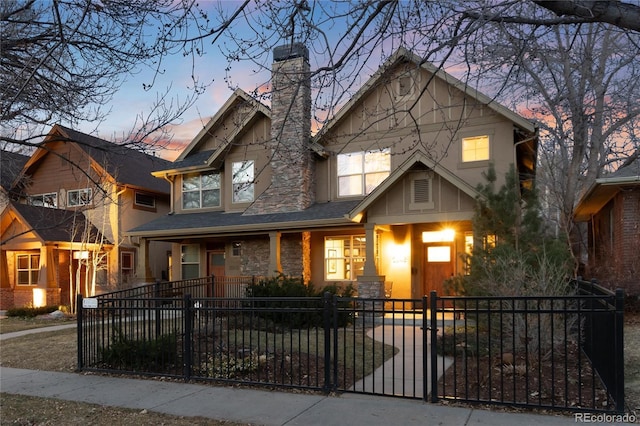 view of front of home featuring a gate, a fenced front yard, stone siding, a porch, and a chimney