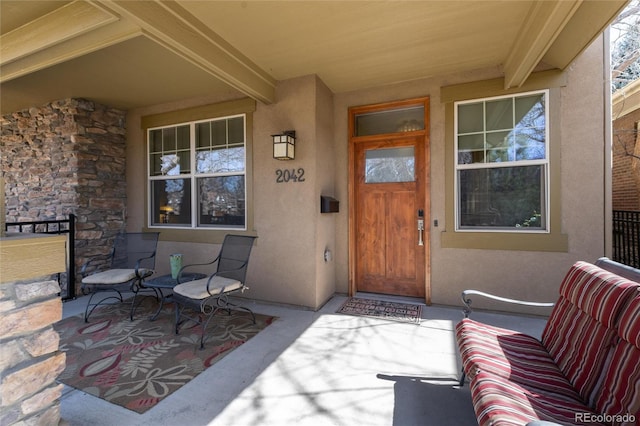 doorway to property with stone siding and stucco siding