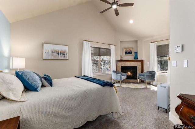 bedroom featuring multiple windows, carpet floors, a lit fireplace, and high vaulted ceiling