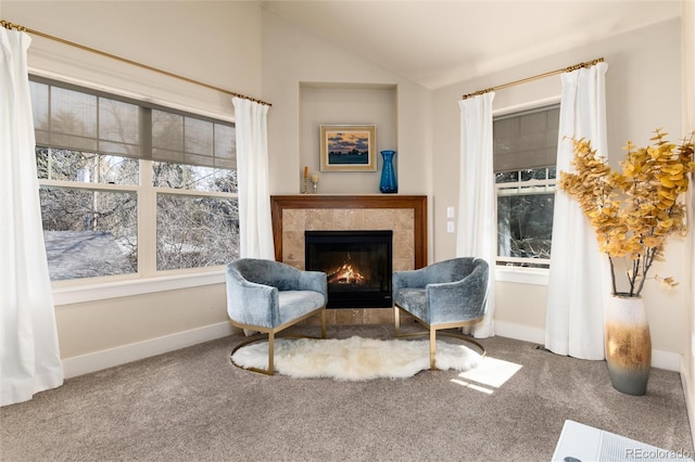 living area featuring plenty of natural light, carpet flooring, a tile fireplace, and lofted ceiling