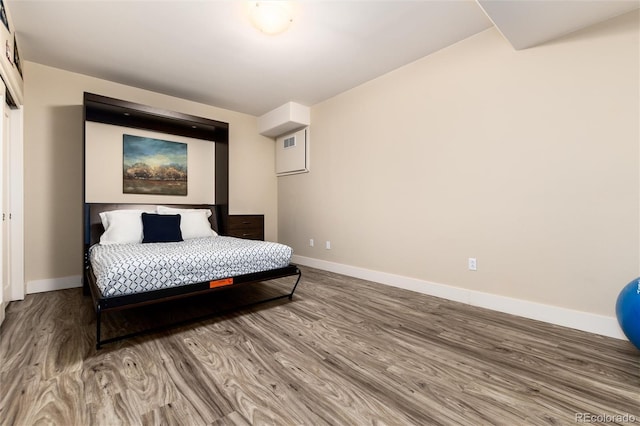 bedroom featuring visible vents, baseboards, and wood finished floors