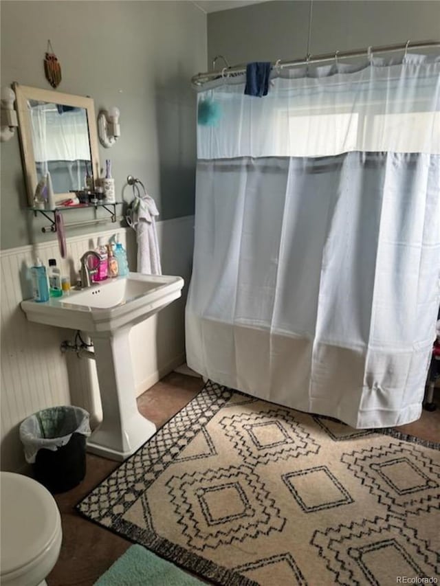 bathroom featuring shower / tub combo with curtain and toilet