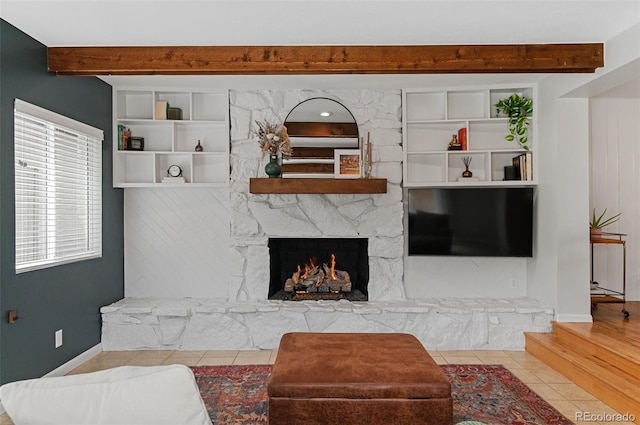 living area with beam ceiling, a fireplace, tile patterned flooring, and baseboards