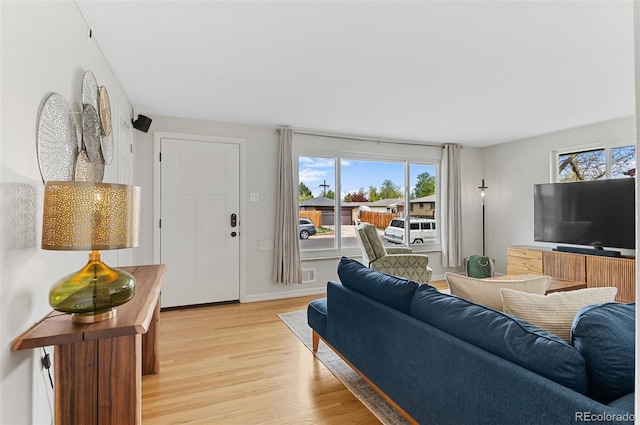living area with light wood-type flooring and baseboards
