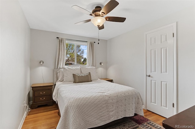 bedroom with light wood-type flooring, baseboards, and a ceiling fan