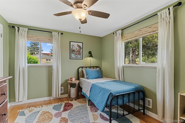 bedroom with baseboards, wood finished floors, and a ceiling fan