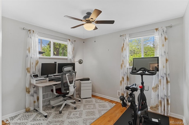 office space featuring a ceiling fan, wood finished floors, and baseboards