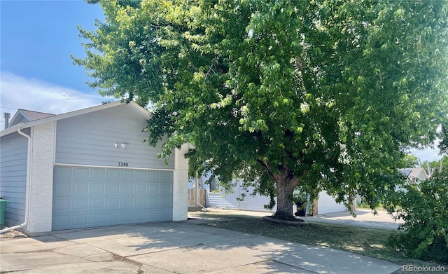 7240 W Yale Ave, Denver, CO 80227 - view of home's exterior featuring brick siding, concrete driveway, and an attached garage