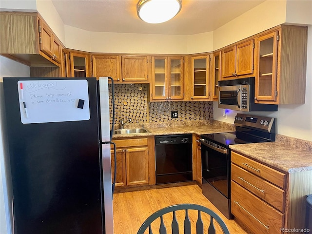 7240 W Yale Ave, Denver, CO 80227 - kitchen with appliances with stainless steel finishes, brown cabinets, light wood-style flooring, decorative backsplash, and light countertops