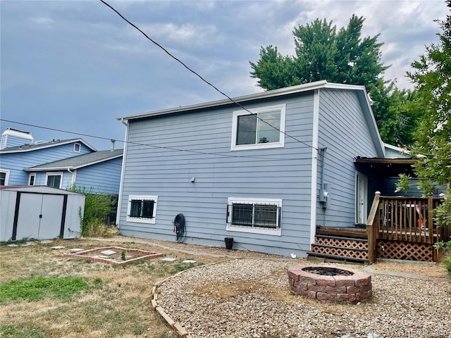 7240 W Yale Ave, Denver, CO 80227 - rear view of house with an outdoor fire pit, a storage shed, a deck, and a garden
