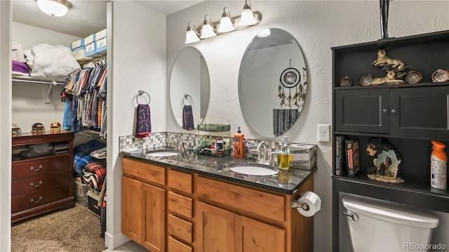 1086 Johnson St, Wiggins, CO 80654 - full bathroom with double vanity, toilet, and a walk in closet