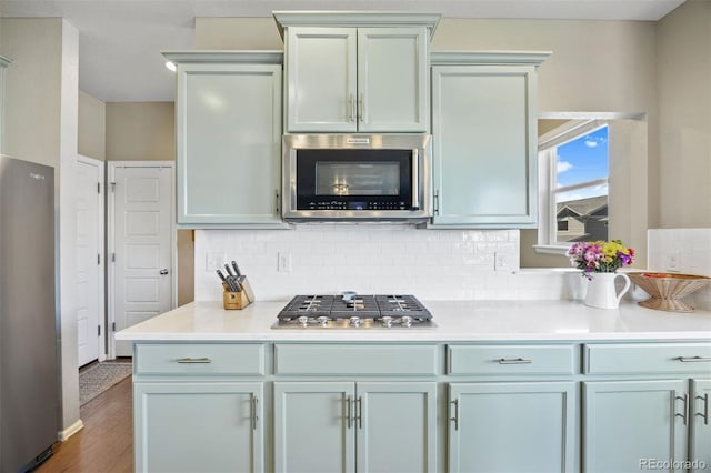20855 Park Hollow Dr, Parker, CO 80138 - kitchen with stainless steel appliances, decorative backsplash, light countertops, and wood finished floors