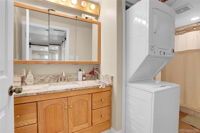 724 County Road 37, Brighton, CO 80603 - bathroom with wood finished floors, stacked washing maching and dryer, and vanity