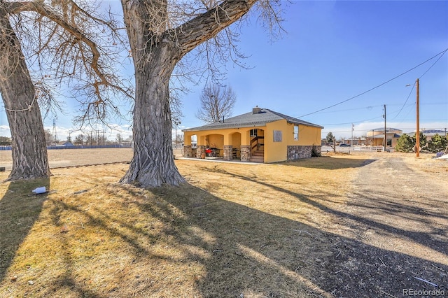724 County Road 37, Brighton, CO 80603 - exterior space with a chimney, stucco siding, and a yard