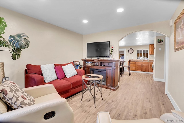 724 County Road 37, Brighton, CO 80603 - living area with arched walkways, baseboards, recessed lighting, and light wood finished floors
