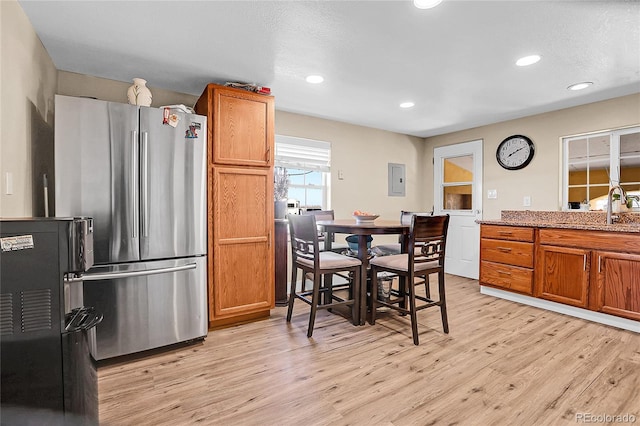 724 County Road 37, Brighton, CO 80603 - kitchen with brown cabinets, light wood-style flooring, and freestanding refrigerator