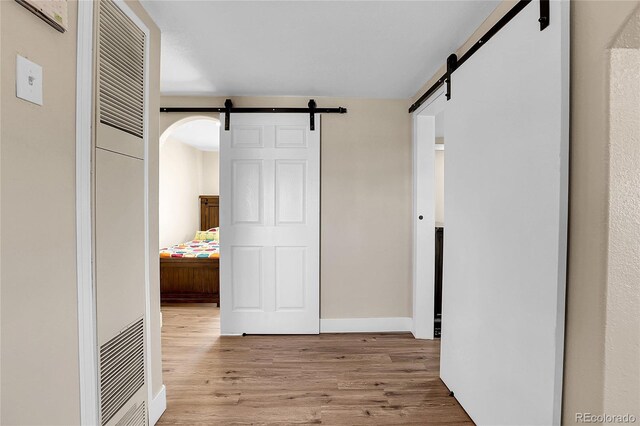 724 County Road 37, Brighton, CO 80603 - hallway with baseboards, visible vents, a barn door, and wood finished floors