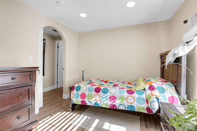 724 County Road 37, Brighton, CO 80603 - bedroom featuring arched walkways, recessed lighting, baseboards, and light wood-style floors