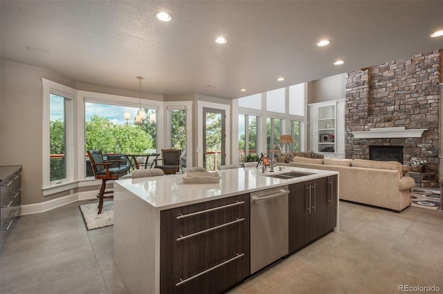 171 October Pl, Castle Rock, CO 80104 - kitchen featuring stainless steel dishwasher, dark brown cabinets, light countertops, recessed lighting, and a fireplace