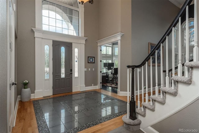 171 October Pl, Castle Rock, CO 80104 - entrance foyer with wood finished floors, a high ceiling, and stairway