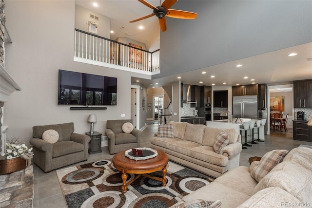 171 October Pl, Castle Rock, CO 80104 - tiled living room featuring a ceiling fan, recessed lighting, a fireplace, and a towering ceiling