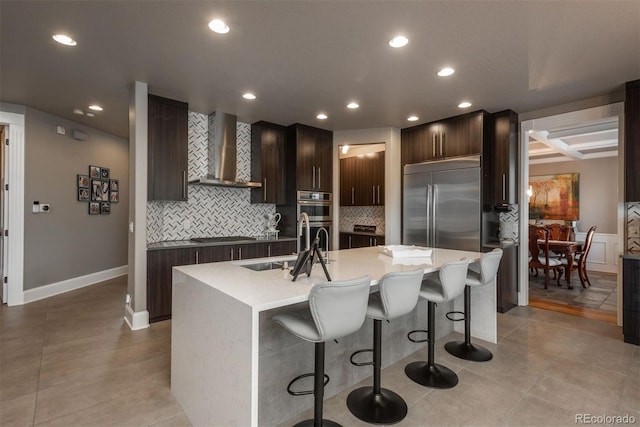171 October Pl, Castle Rock, CO 80104 - kitchen with wall chimney exhaust hood, appliances with stainless steel finishes, a kitchen island with sink, a kitchen breakfast bar, and recessed lighting
