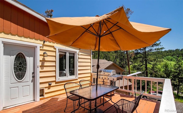 4805 S Blue Spruce Rd, Evergreen, CO 80439 - wooden deck with outdoor dining area, grilling area, and a forest view