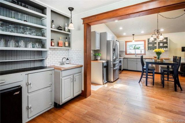 4805 S Blue Spruce Rd, Evergreen, CO 80439 - kitchen with stainless steel fridge with ice dispenser, open shelves, backsplash, light wood-type flooring, and recessed lighting
