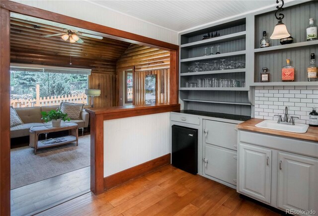 4805 S Blue Spruce Rd, Evergreen, CO 80439 - bar area featuring ceiling fan, light wood-type flooring, vaulted ceiling, and pendant lighting