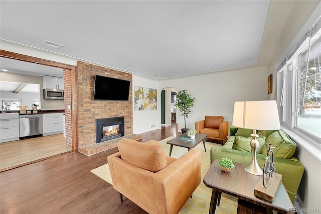 living room with wood-type flooring and a fireplace