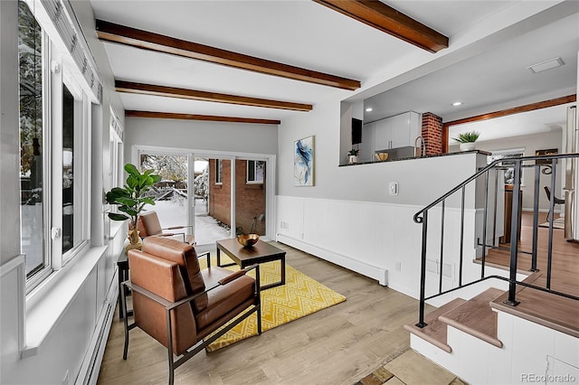 living room featuring a baseboard radiator, light wood-type flooring, and beam ceiling