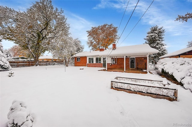 view of snow covered back of property