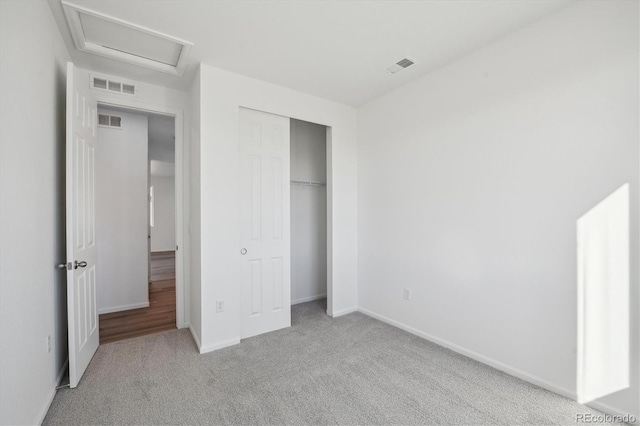 unfurnished bedroom with a closet and light colored carpet