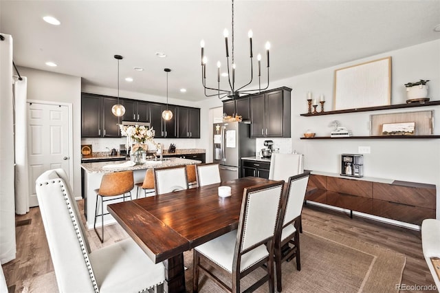 dining space featuring dark hardwood / wood-style floors and an inviting chandelier