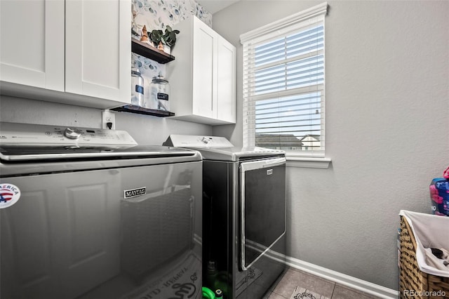 washroom with cabinets, plenty of natural light, and washing machine and dryer