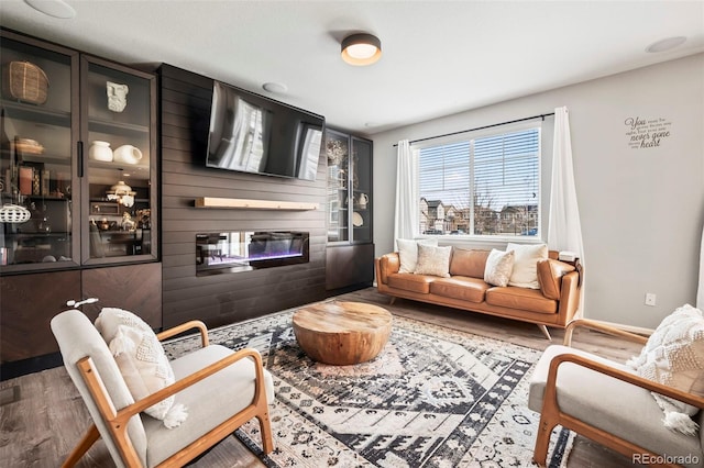 living room with hardwood / wood-style floors and a large fireplace