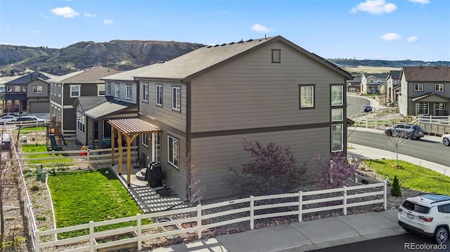 view of front of property with a fenced front yard, a residential view, and a mountain view