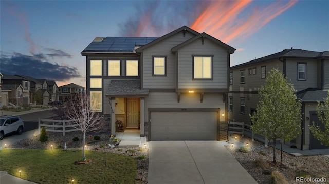 view of front of home featuring solar panels, a yard, and a garage