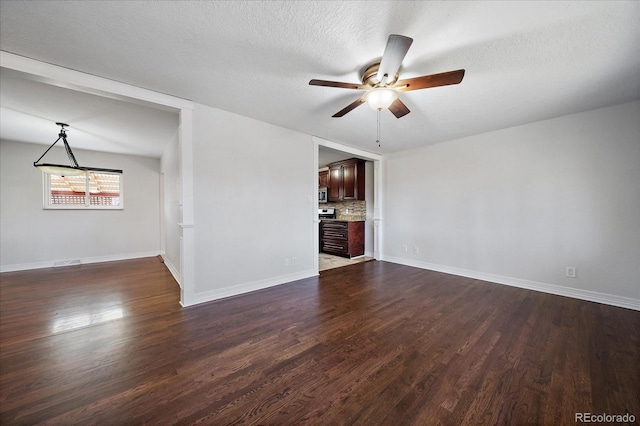 unfurnished living room with ceiling fan, dark hardwood / wood-style flooring, and a textured ceiling